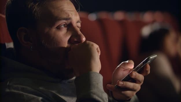 A close-up shot of a frustrated moviegoer checking their phone, reading news about another movie release delay, symbolizing audience disappointment and the immediate impact on consumer experience.