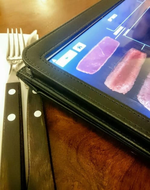 A close-up of a tablet screen displaying the interface of a niche streaming service focused on classic horror films. The interface is simple and user-friendly, showcasing titles like 
