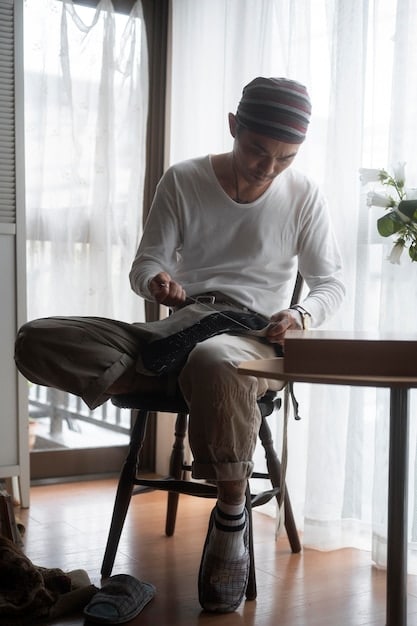 Roman sitting alone in a minimalist apartment, wearing a simple t-shirt and jeans. He's looking at a photo of his father, with a mix of sadness and resignation in his eyes.