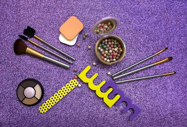 A makeup artist's workstation filled with various makeup products, brushes, sponges, and special effects materials, neatly organized and ready for use. Focus on the array of colors and textures available.