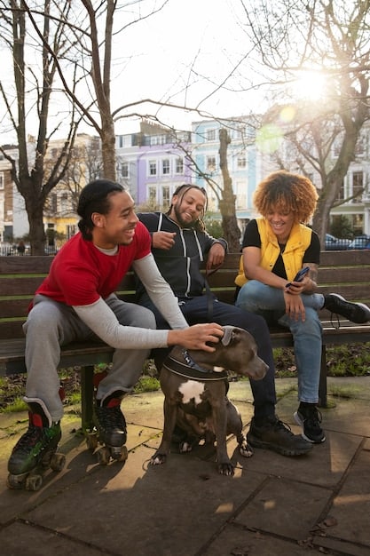 A medium shot of a diverse group of young adults sitting on a park bench at dusk, looking into the distance with a mix of hope and concern. The scene is set in a somewhat run-down urban area, with graffiti visible in the background. The image evokes feelings of community, introspection, and resilience.