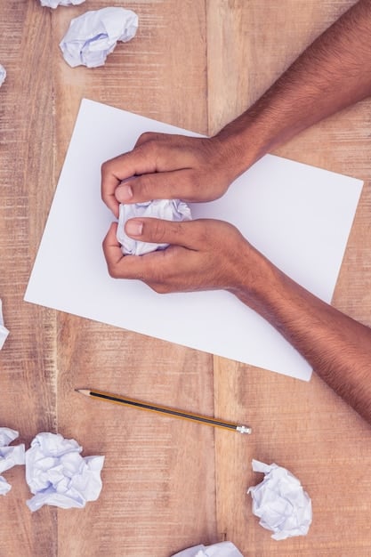 A close-up shot of a hand crumpling a piece of paper, symbolizing the frustration and struggle of writer's block. The background is blurred to keep the focus on the hand and paper.
